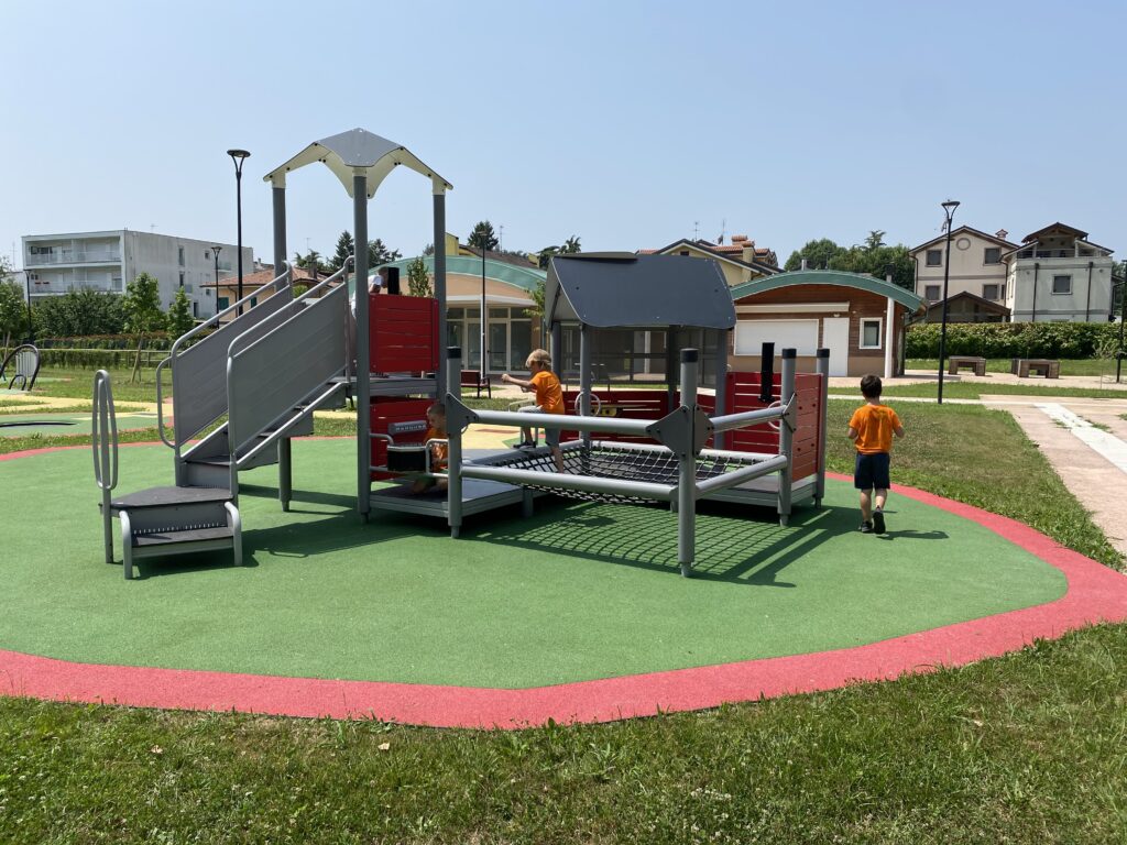 struttura di gioco che richiama un castelletto con rampa d'accesso, scivolo, un tappeto per saltare e alcune plance educative