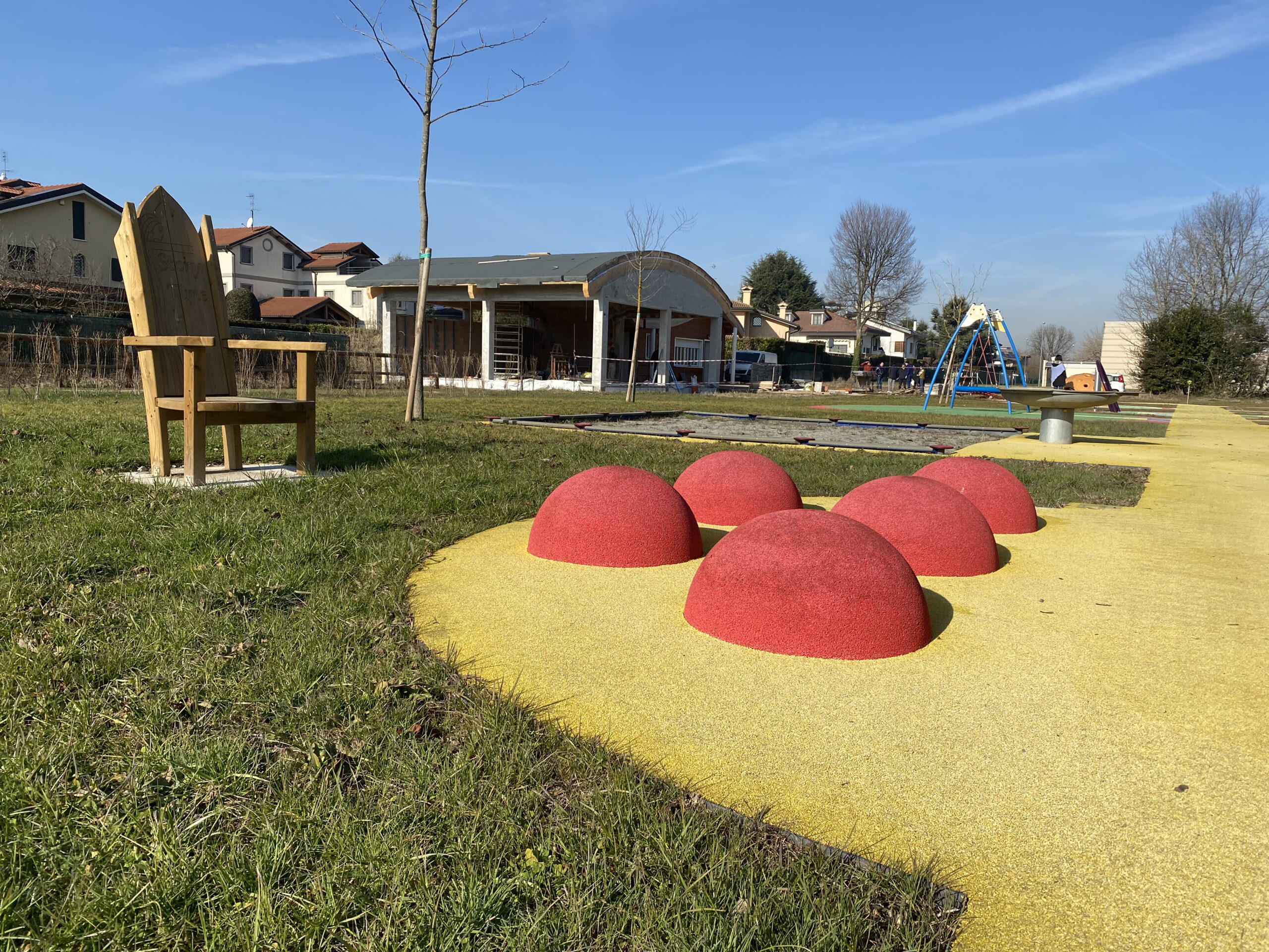 Un grande trono di legno e cinque calottine rosse su cui sedersi o rotolarsi.